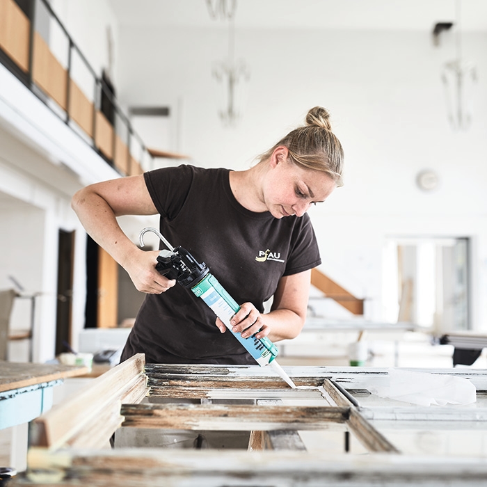 Eine Repair Care Anwendering verkittet eine Fensterscheibe eines historischen Fensters mit DRY SEAL™