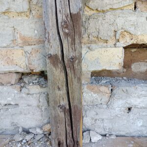 Tiefe Risse im Fachwerkholz deuten auf längere Austrocknung und Witterungseinflüsse hin. Das Holz zeigt Spannungsrisse entlang der Maserung – eine dauerhafte Holzreparatur ist wichtig, um Folgeschäden zu vermeiden.