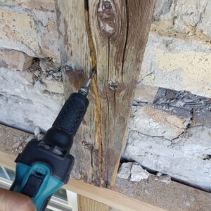 Ausfräsen tiefer Risse im Fachwerkholz zur Vorbereitung einer fachgerechten Reparatur. Die beschädigten Stellen werden für den Einsatz von 2K-Holzspachtel oder Holzergänzungen vorbereitet.