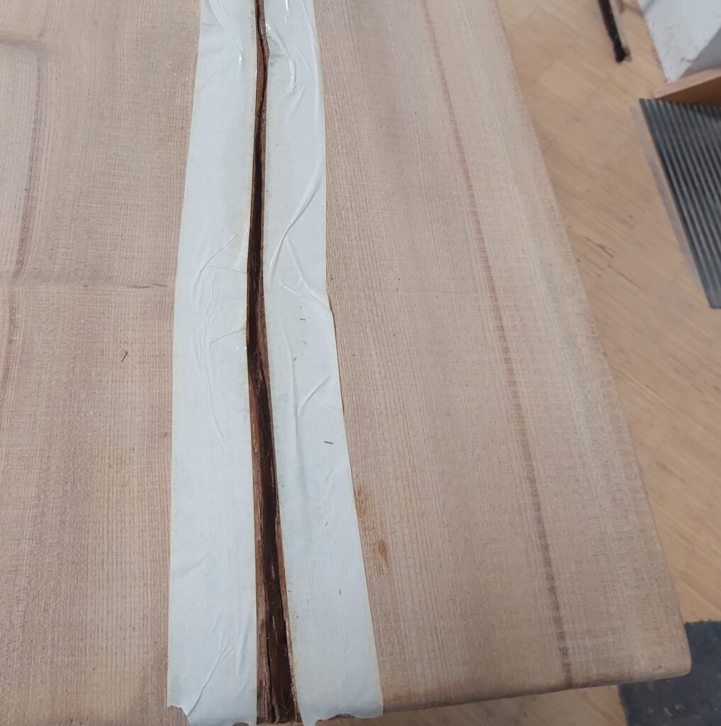 Natürlicher Riss im Holz wird abgeklebt