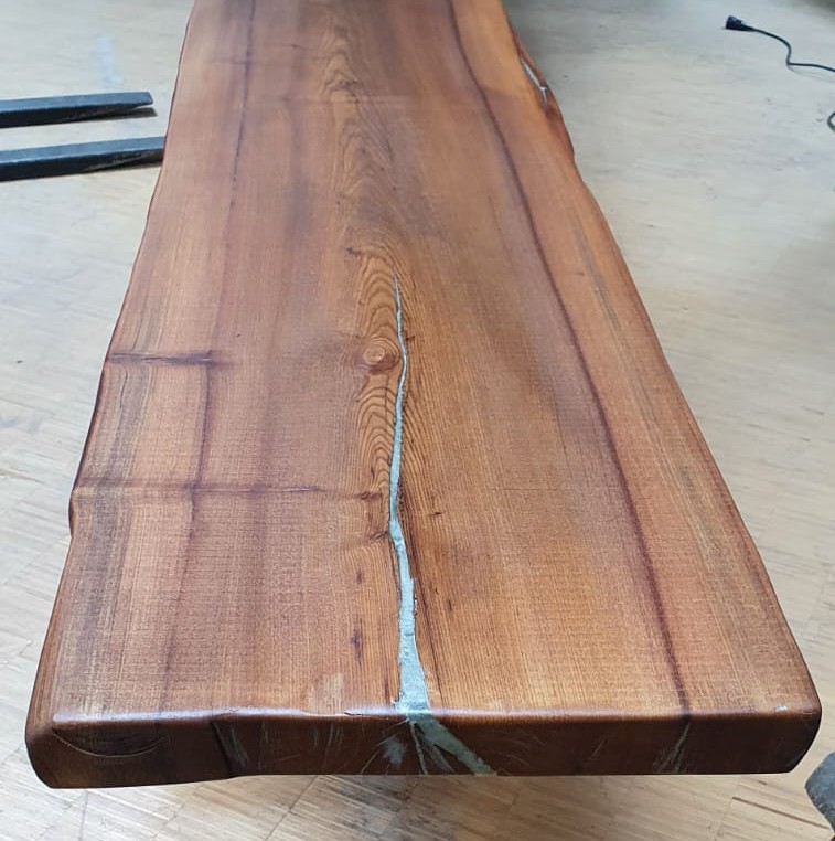 Holzrisse in Tischplatte, die mit silber eingefärbten 2-K-Holzspachtel aufgefüllt wurden